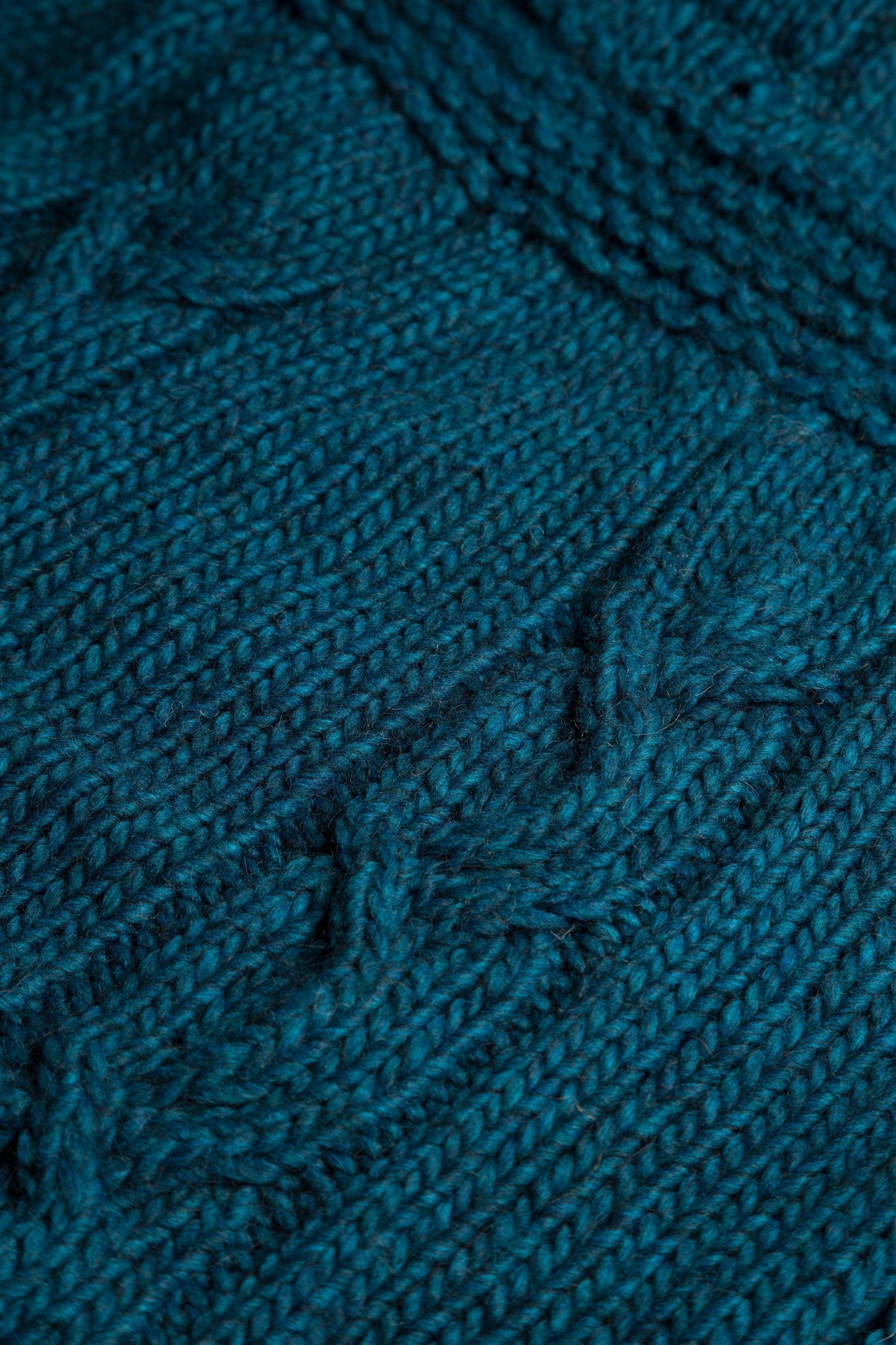 dettaglio scaldacollo a trecce in lana alpaca di colore blu petrolio