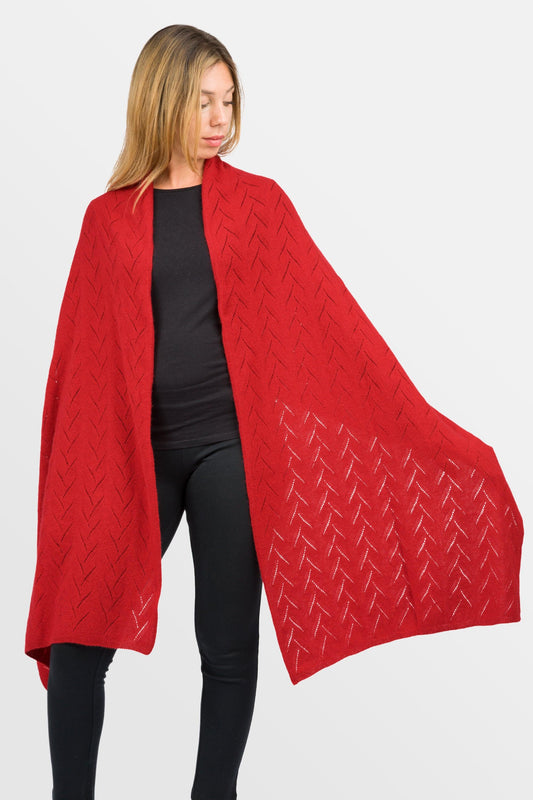 modella che indossa e mostra aperta stola traforata con effetto rami di olivo in misto cashmere da donna di colore rosso