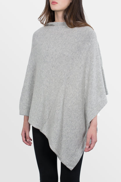 modella che indossa poncho quadrato in misto cashmere di colore grigio perla