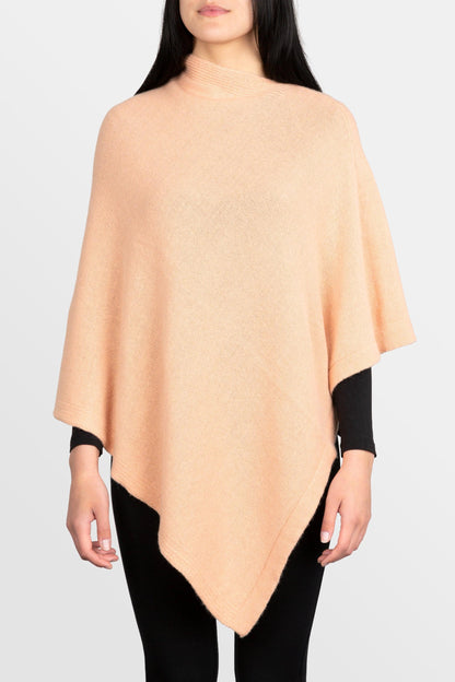 modella che indossa poncho quadrato in misto cashmere di colore rosa salmone