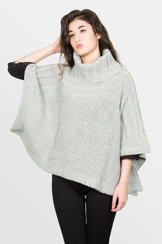 modella che indossa poncho a collo alto in lana di colore grigio perla